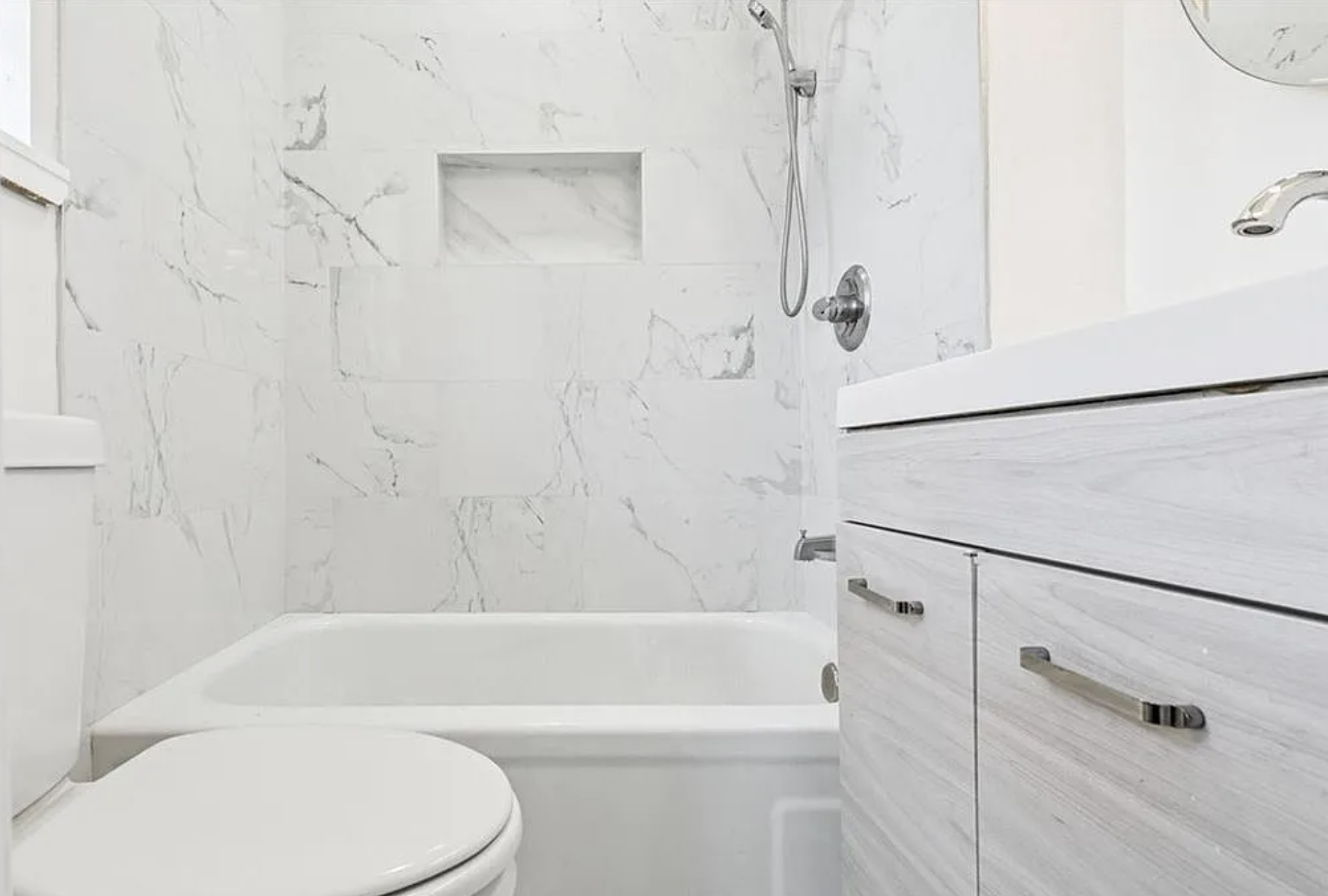 Updated bathroom with marble-look tile shower and modern vanity
